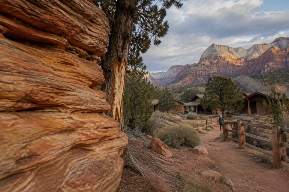 Layered rock cliffs glowing under late afternoon light on a high desert plateau