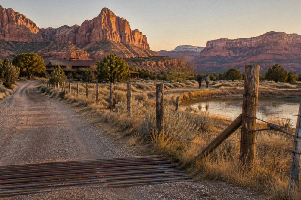 Golden light across open rangeland with distant mesas on the horizon