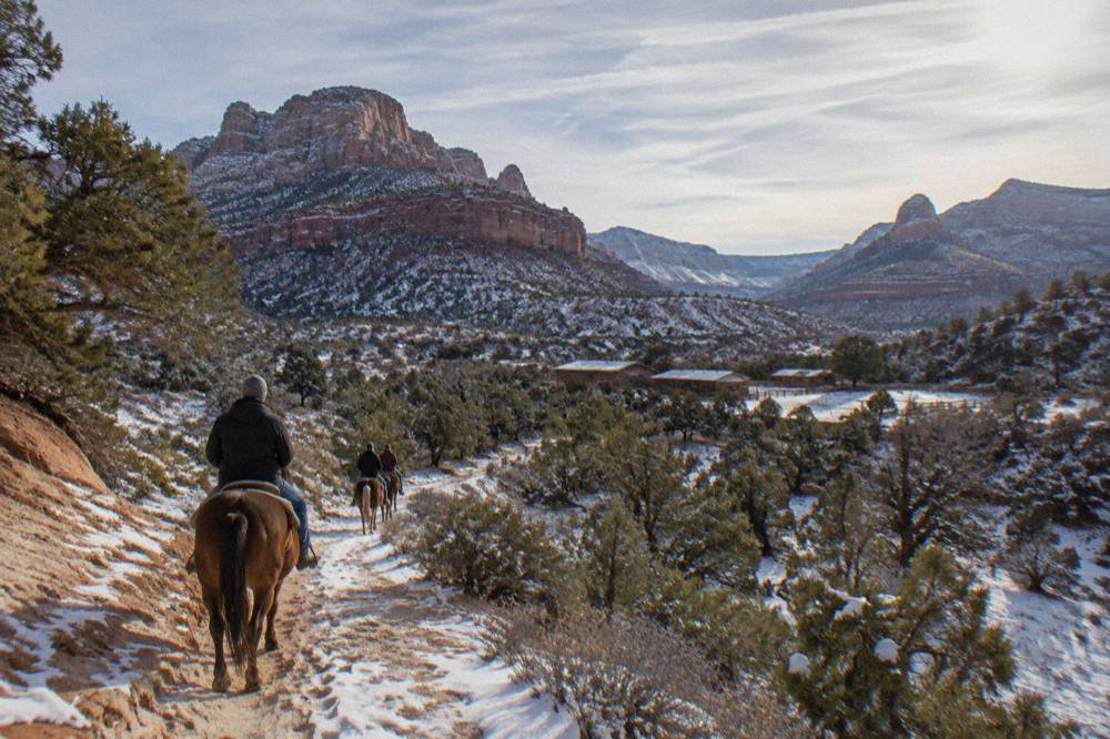 Horse trail winding through juniper and piñon woodland toward distant mesas