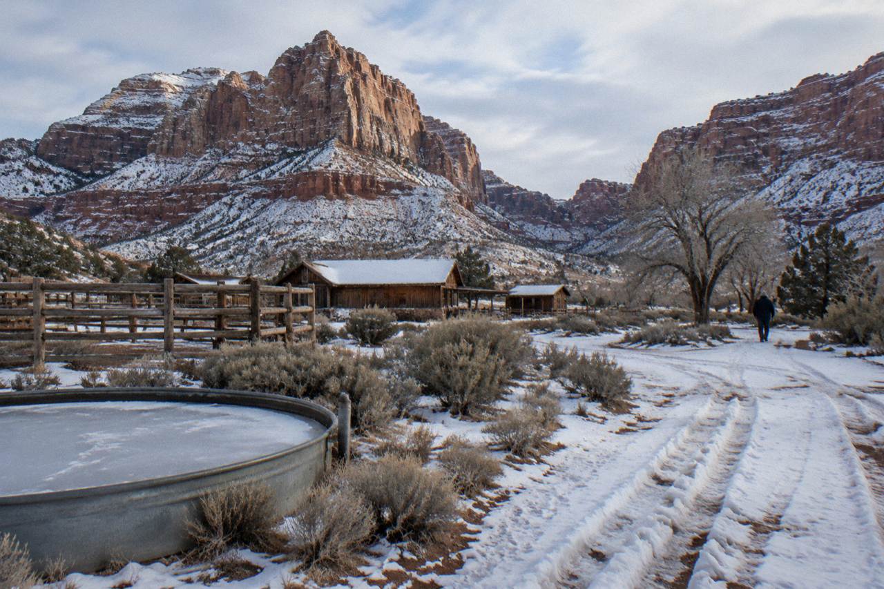 Snow-dusted red rock cliffs above a quiet desert valley in southern Utah