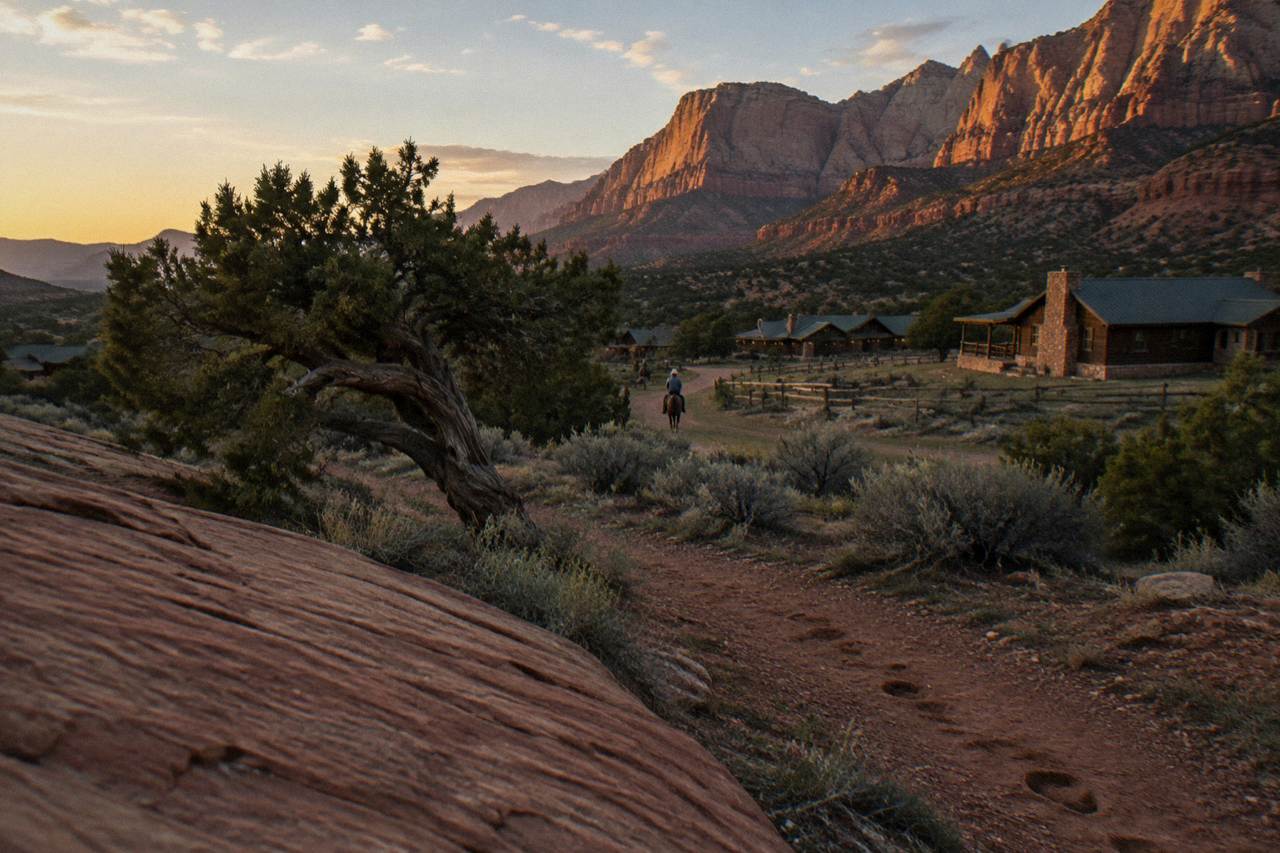 Golden evening light on red rock cliffs above a sage plain near Zion